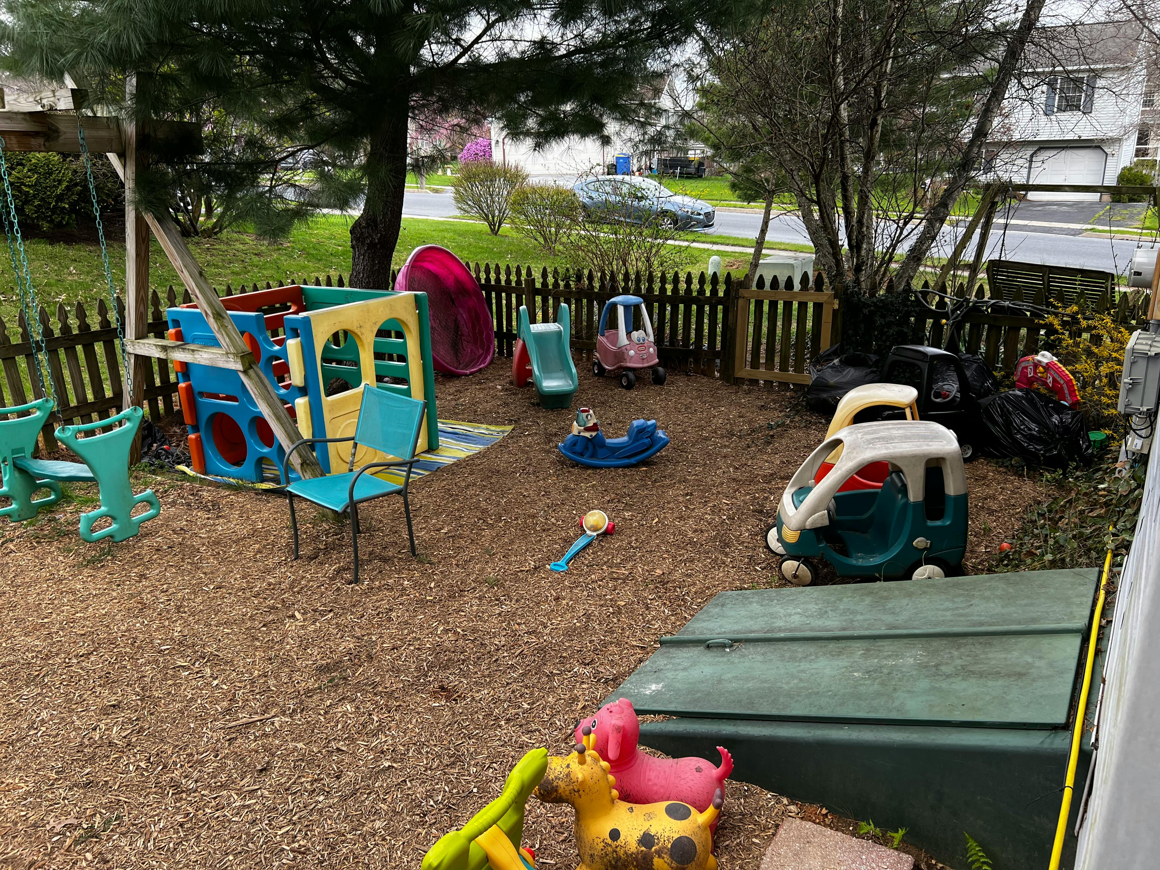 Outdoor play area with swings, slides, and ride-on toys