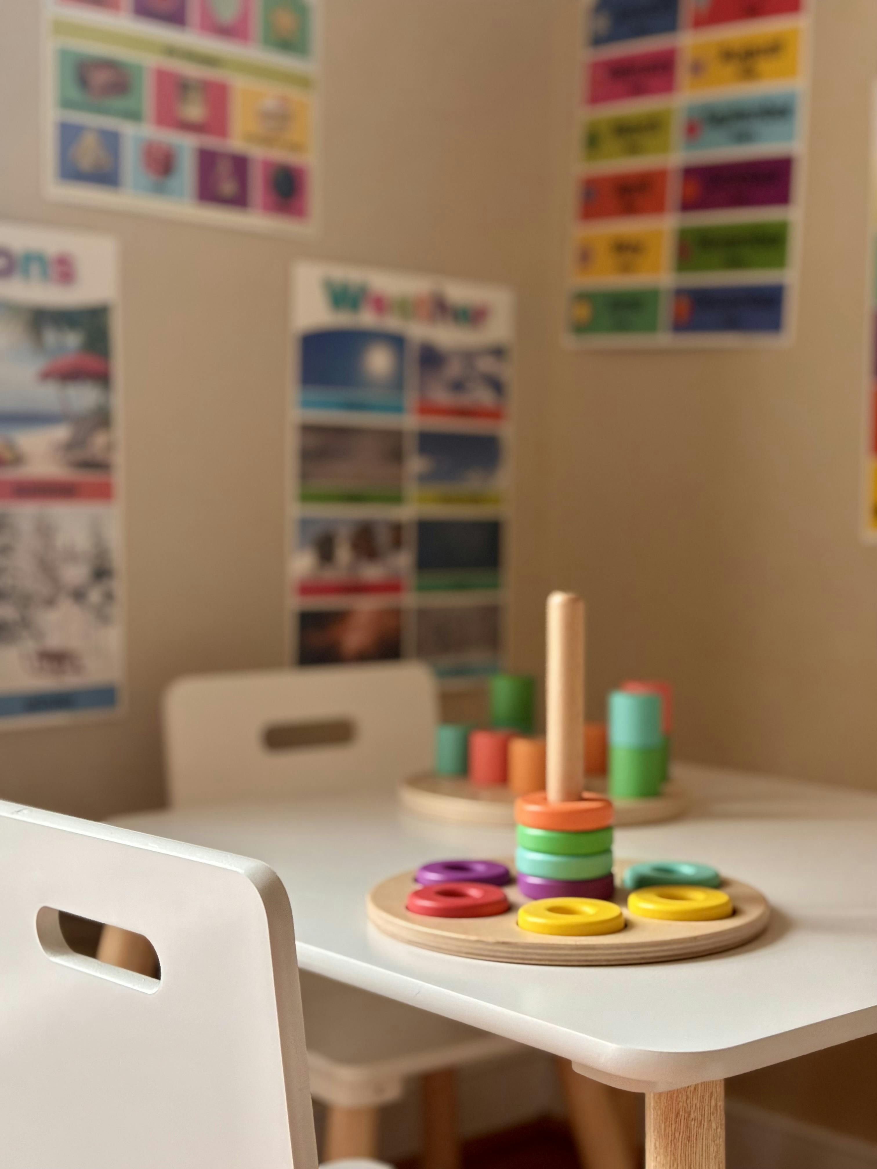 Colorful ring stacking toy on a small wooden table in a playroom