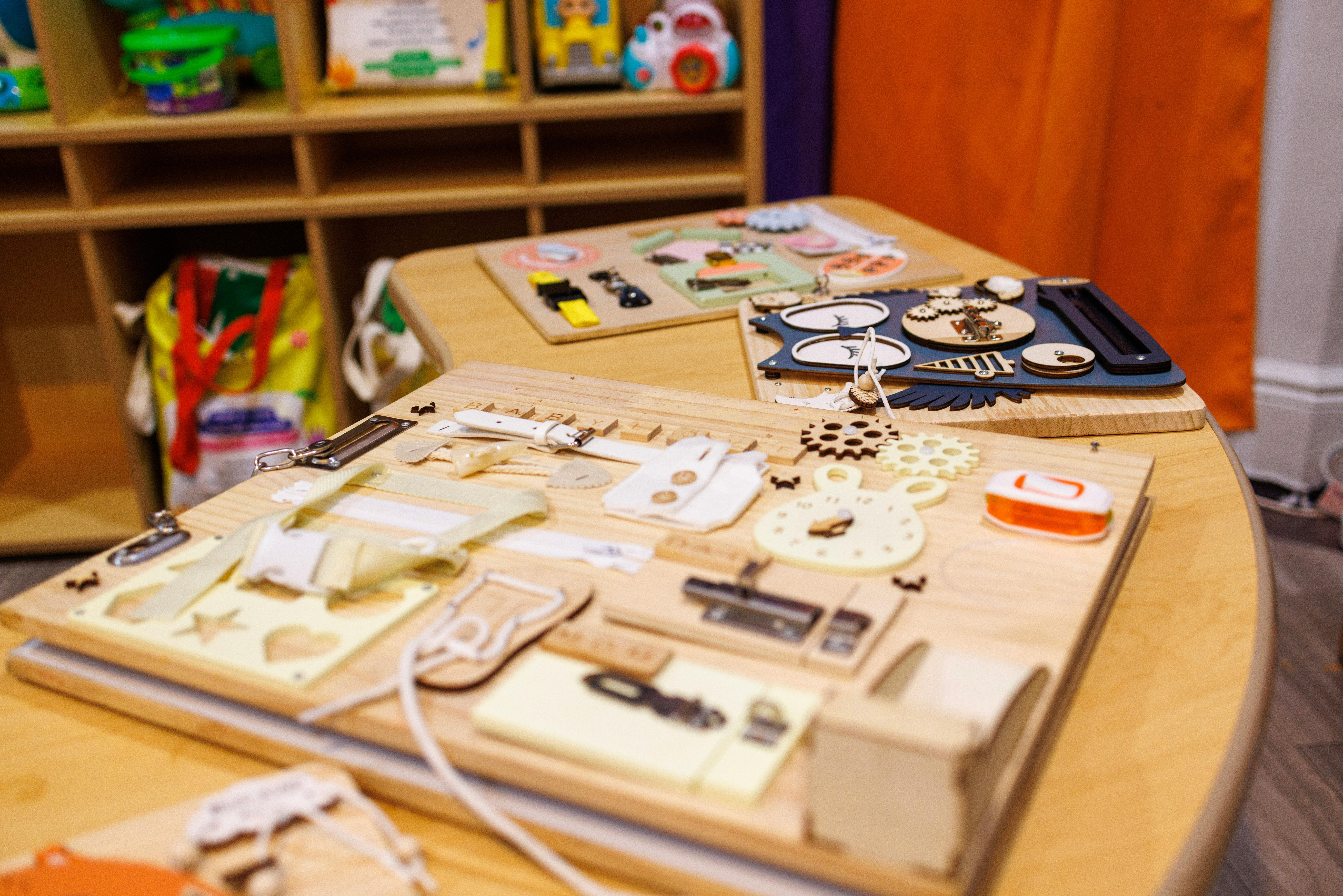 Busy boards with various latches, buckles, and gears on a table