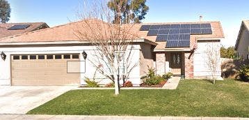 House with solar panels on the roof and a two-car garage
