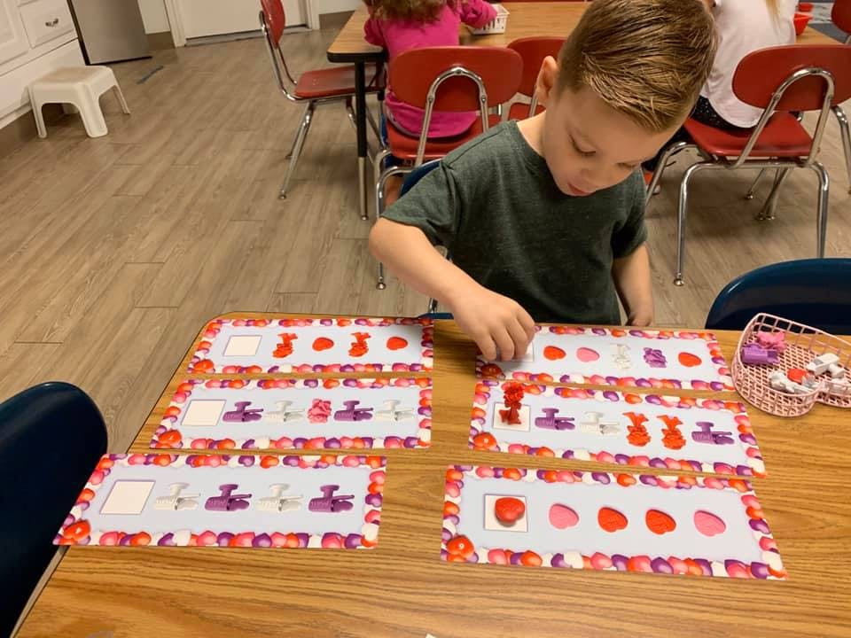 Child playing with learning cards on a table