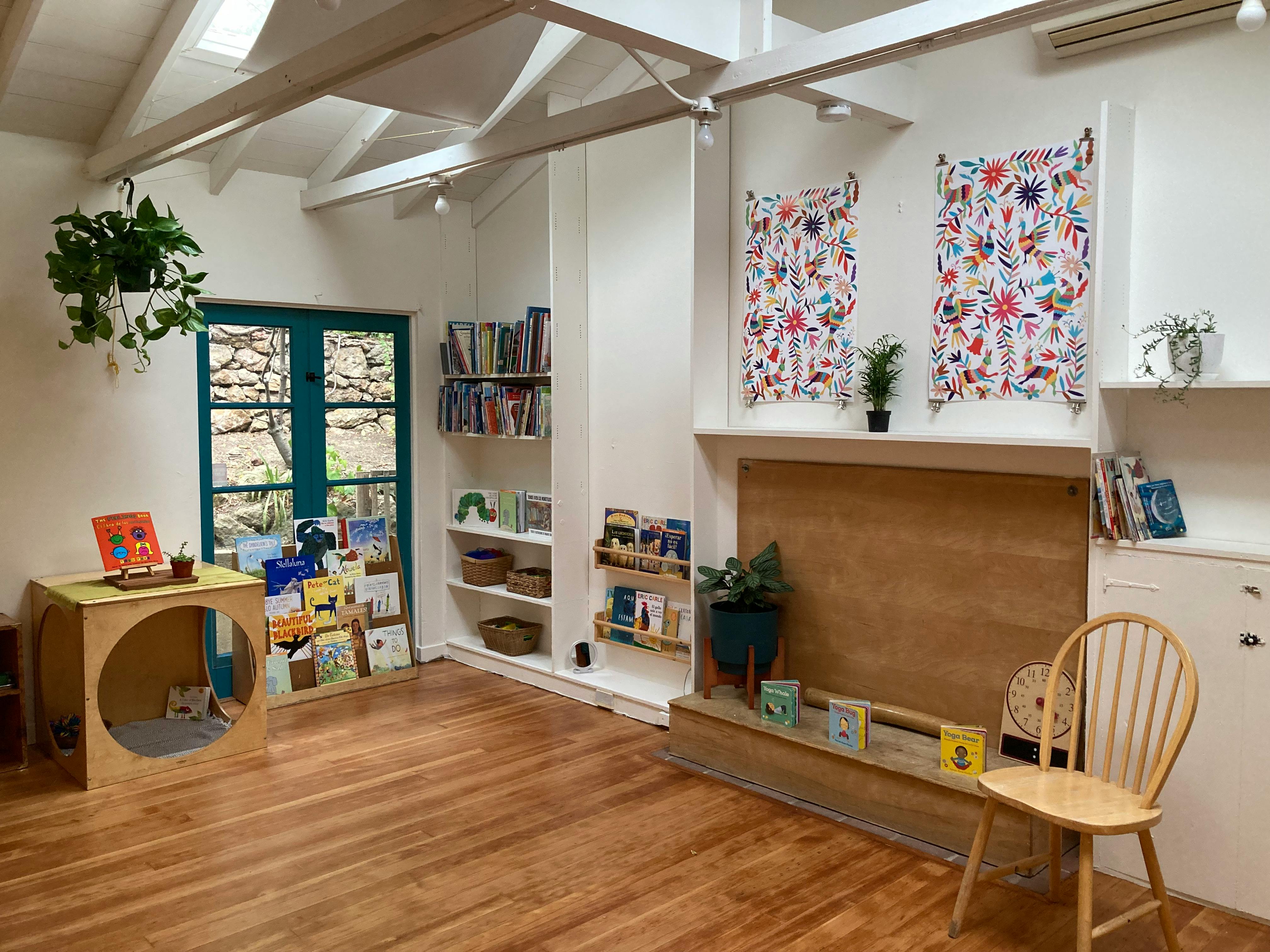 Room with wooden floor, bookshelves, and a window