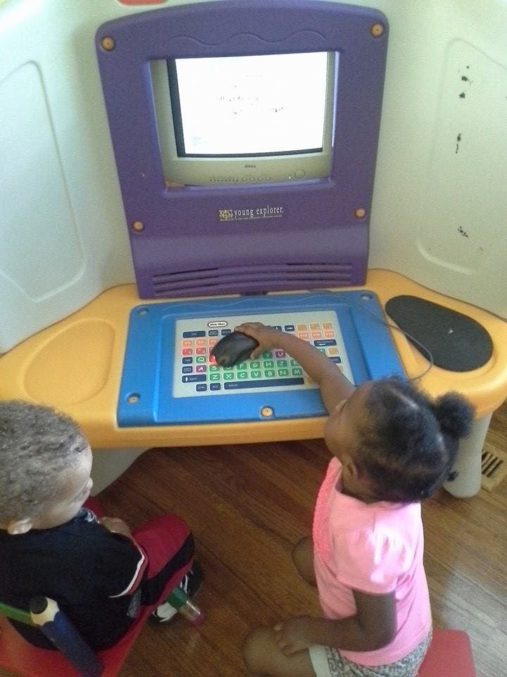 Two children playing with a toy computer