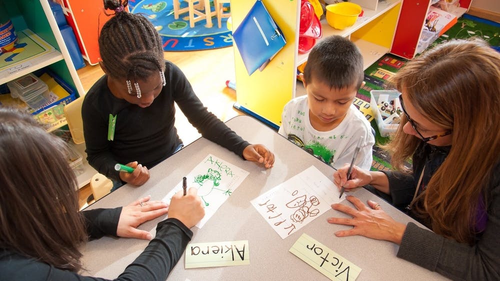 Adults and children drawing at a table