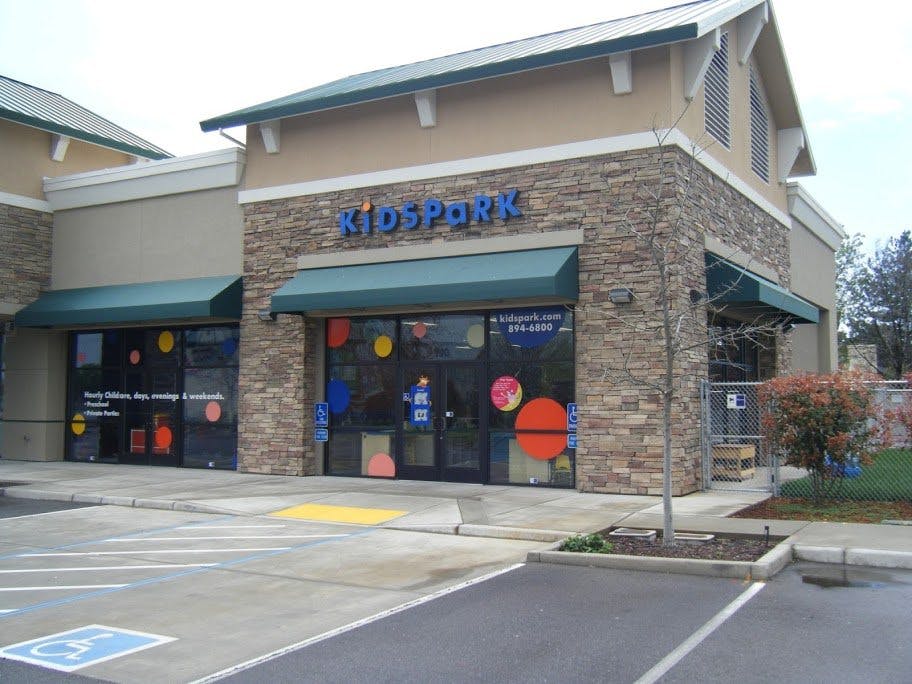 Building with "KIDSPARK" sign and colorful window decorations