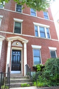 Brick building with a black front door and steps