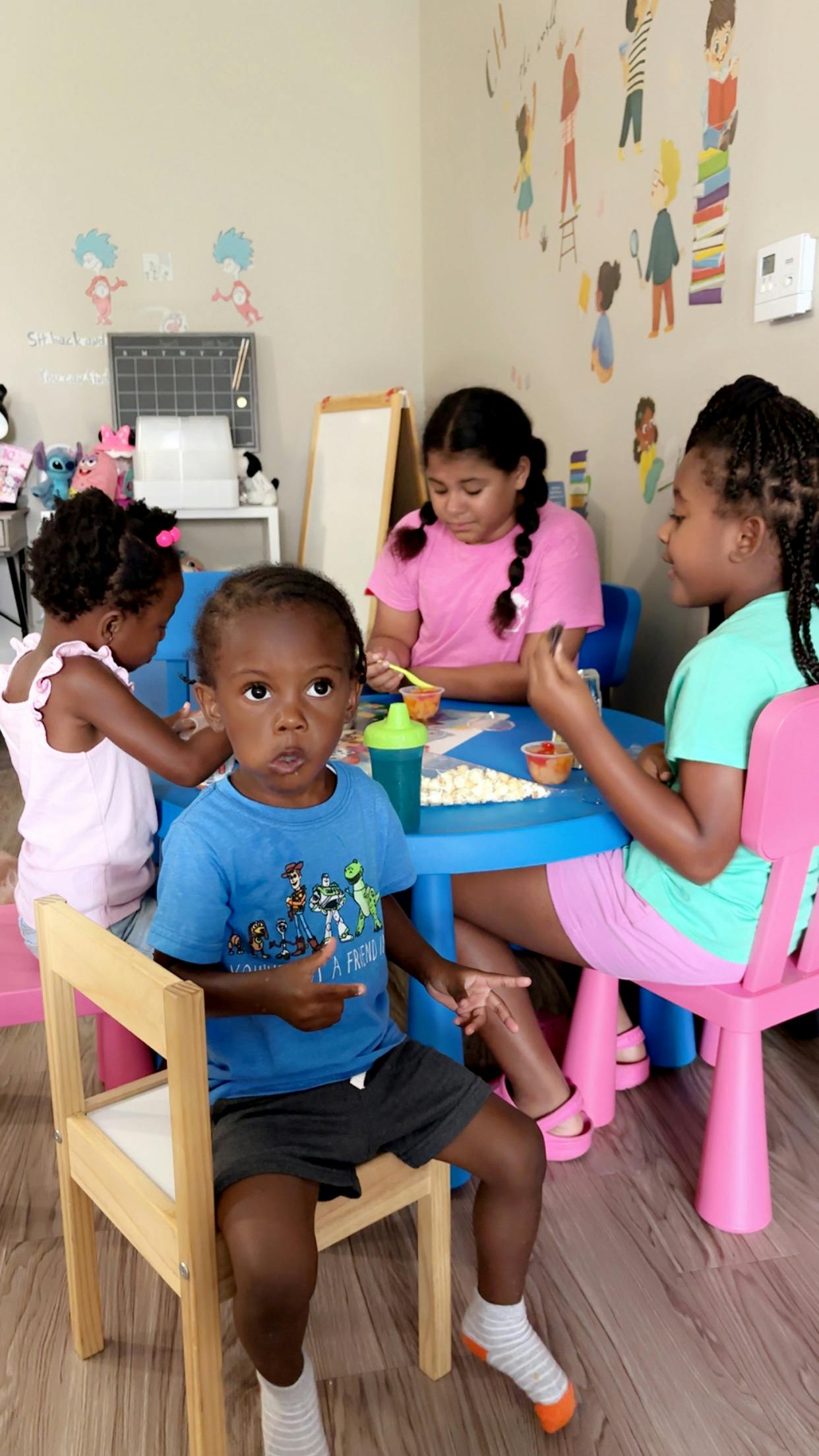 Four children sitting around a small blue table