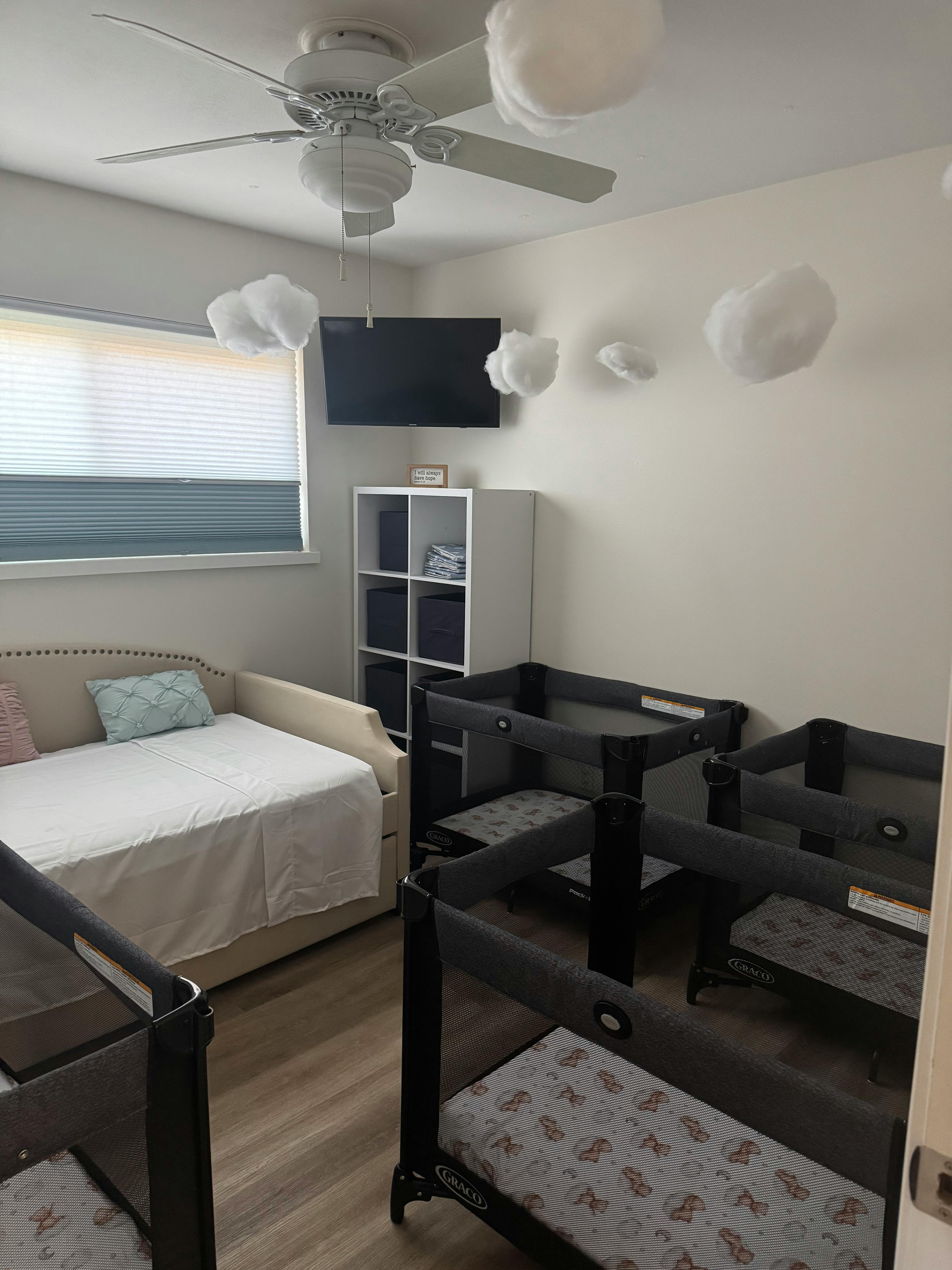 Room with multiple cribs and a daybed