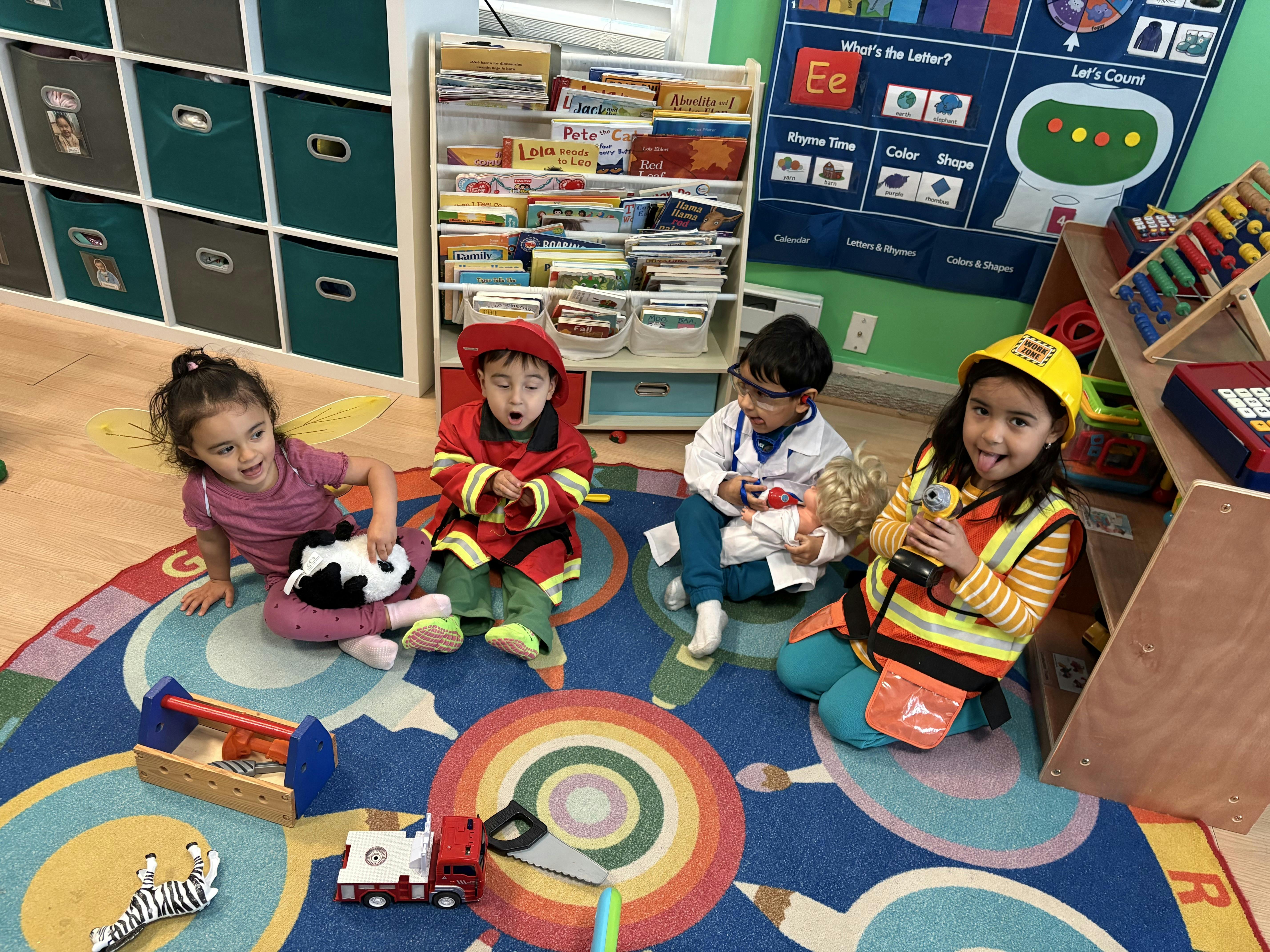 Four children playing dress-up in a classroom