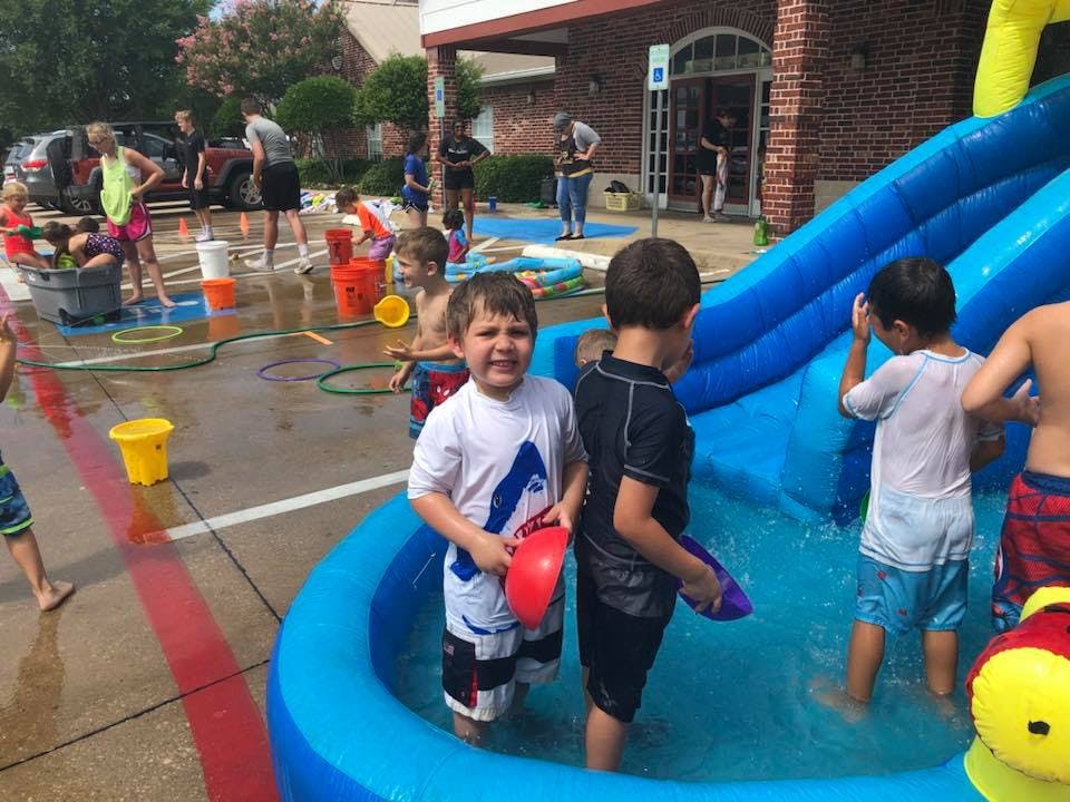 Children playing in an inflatable pool with a slide