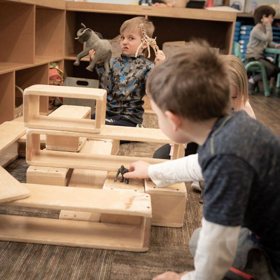 Children playing with wooden blocks and animal toys
