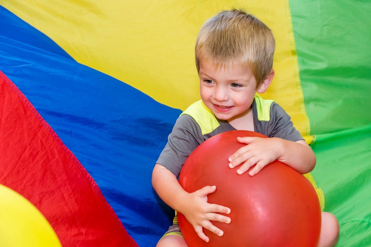 Child holding a red balloon