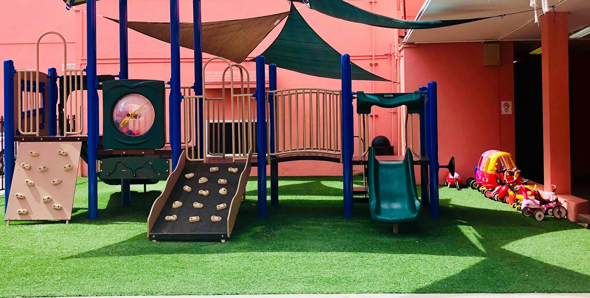 Playground with slides and climbing wall on artificial turf