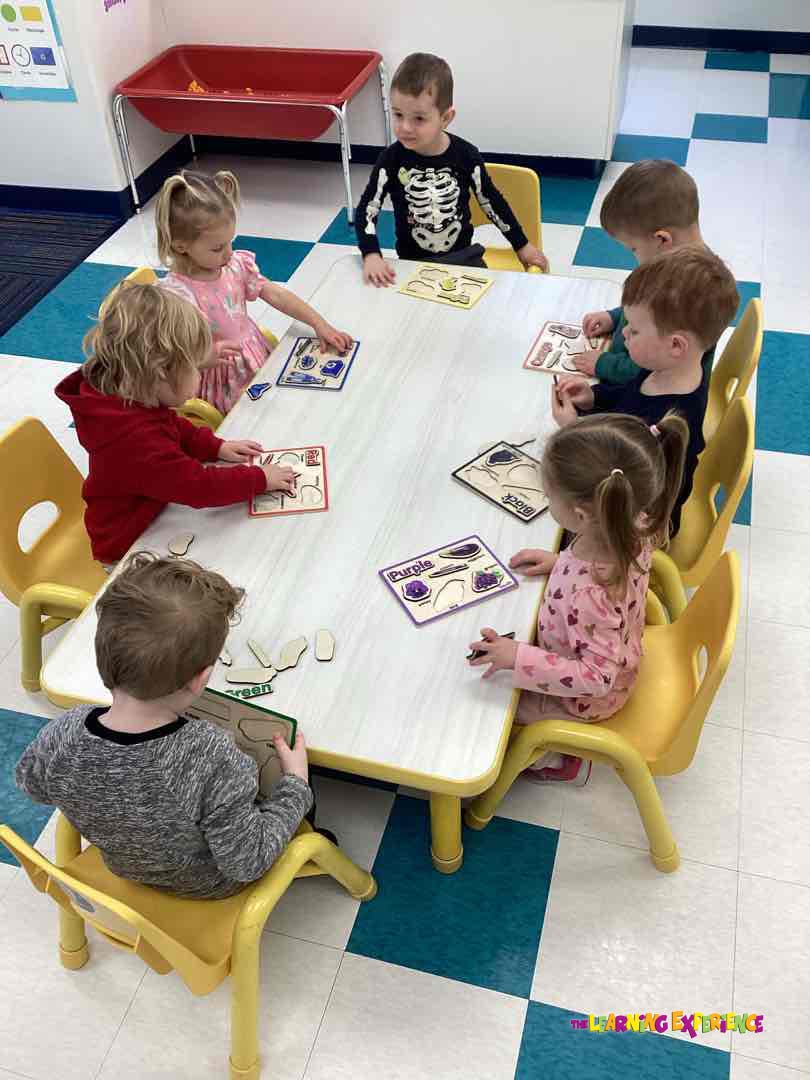 Group of children seated at a table playing with puzzles