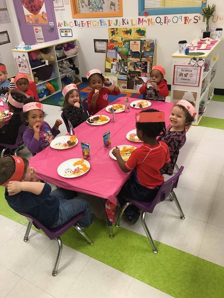 Children eating at a table in a classroom