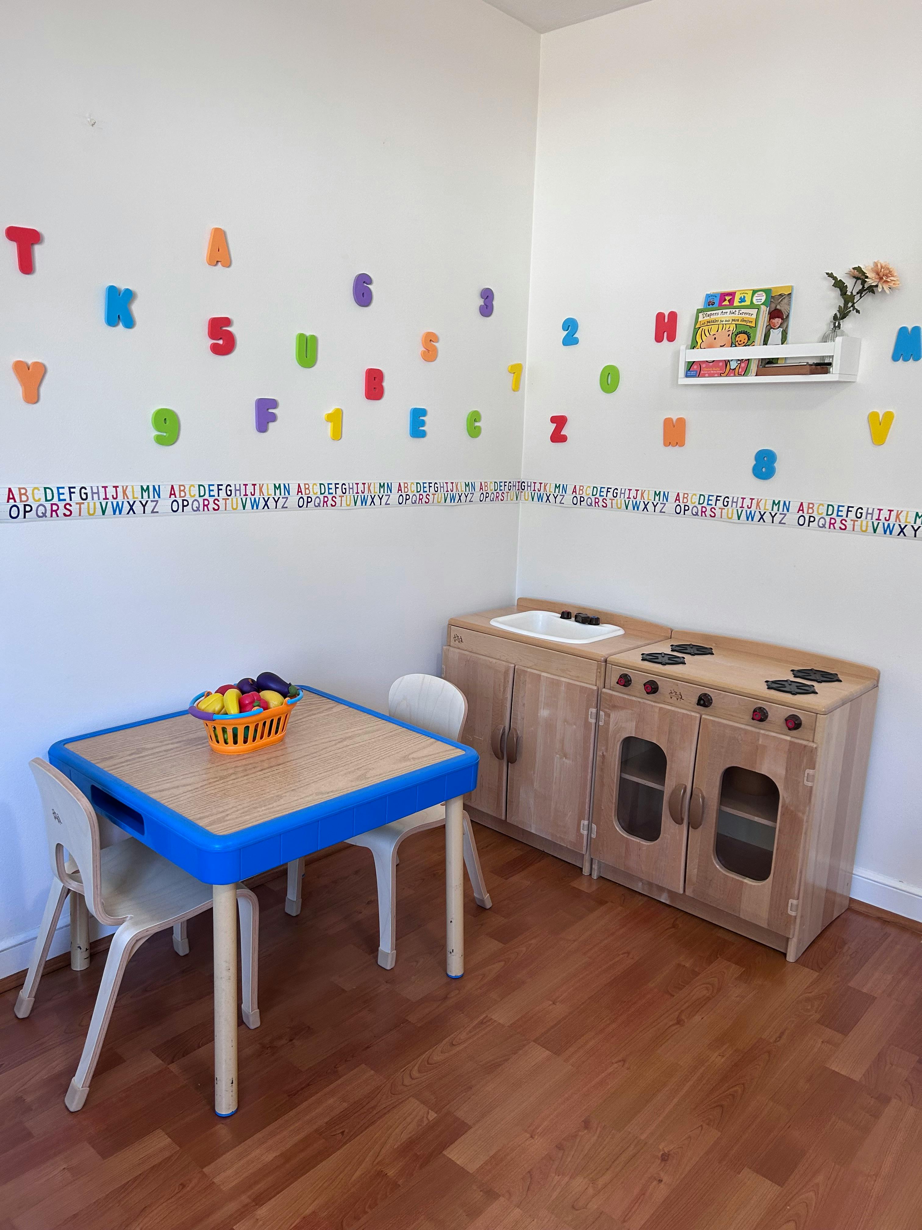 Playroom with a small table and chairs, and a toy kitchen set