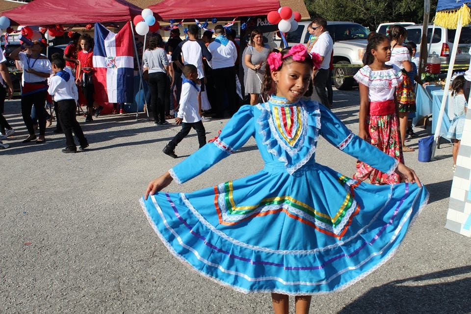 Child in blue dress with full skirt dancing outdoors