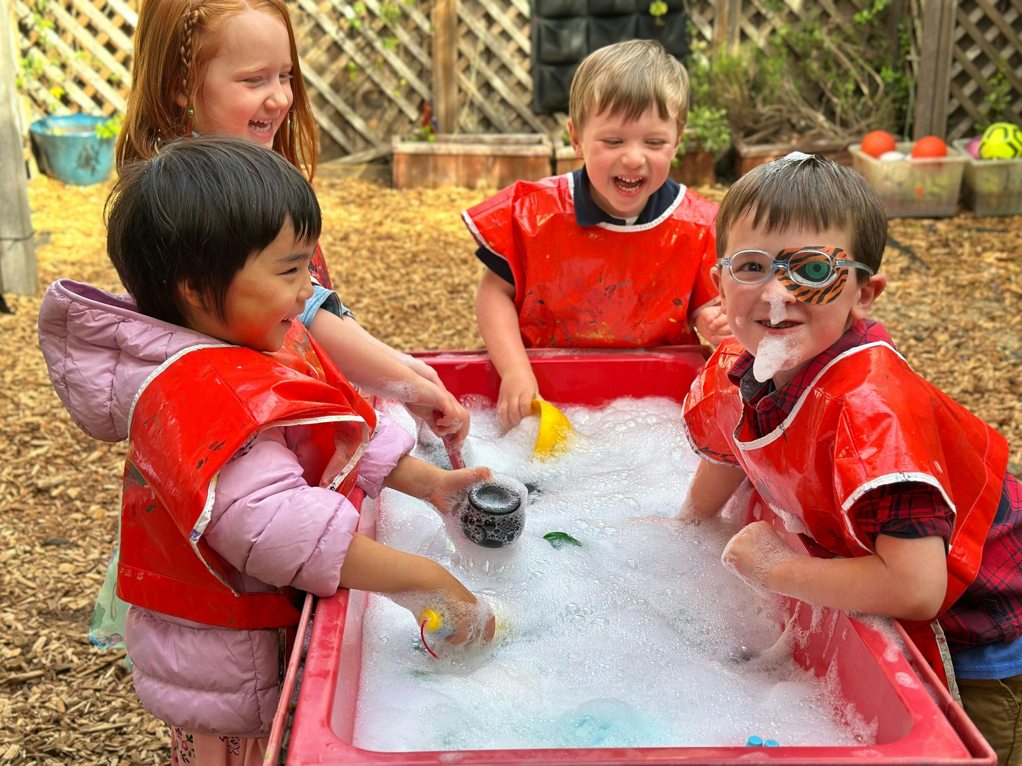 Children playing in a water table with bubbles