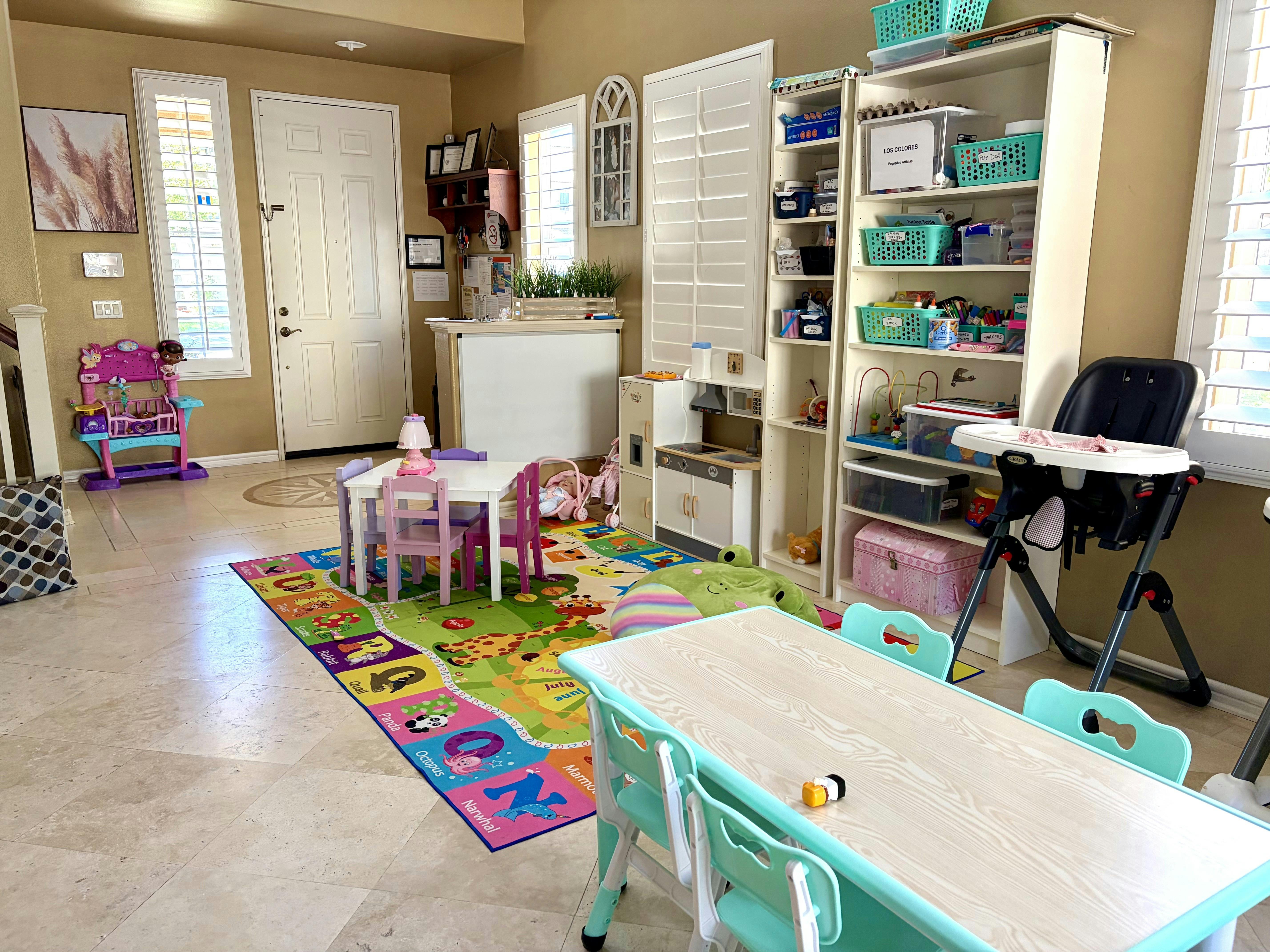 Playroom with children tables, shelves, and a colorful alphabet rug
