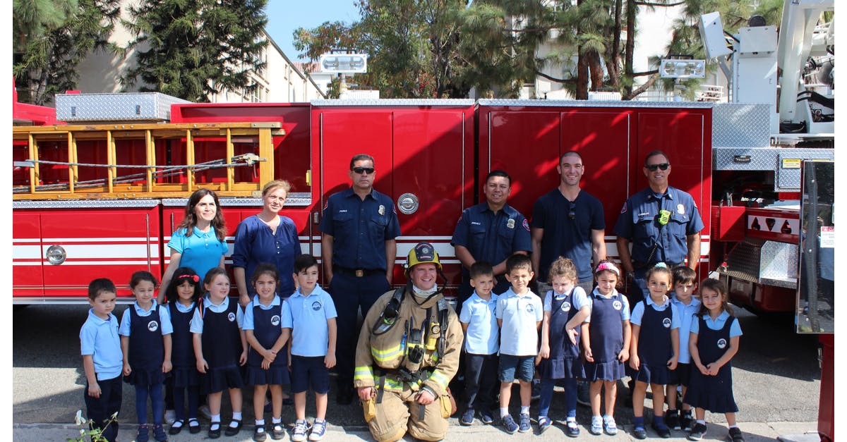 People and children in front of a fire truck