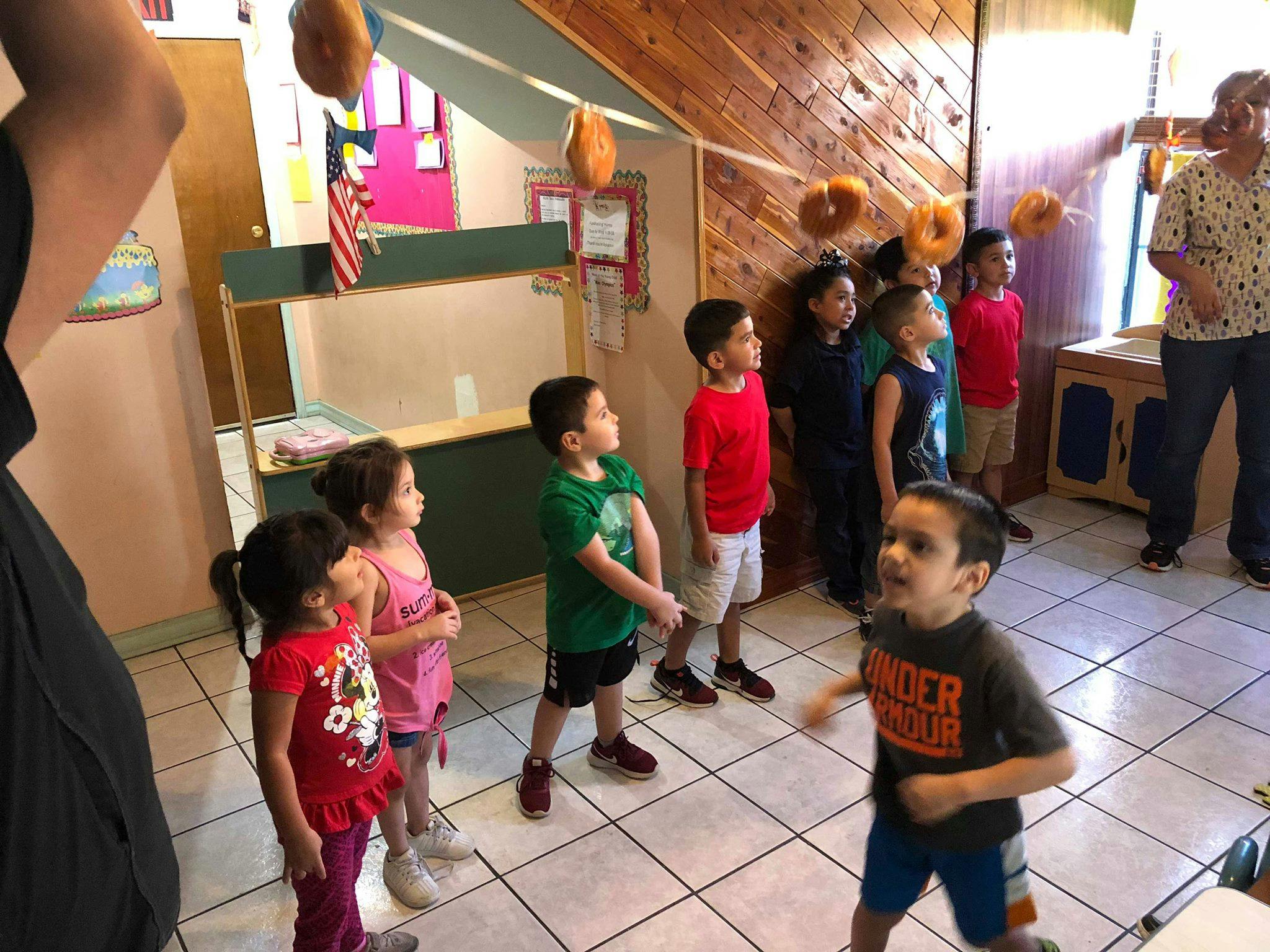 Children standing and looking up at hanging objects
