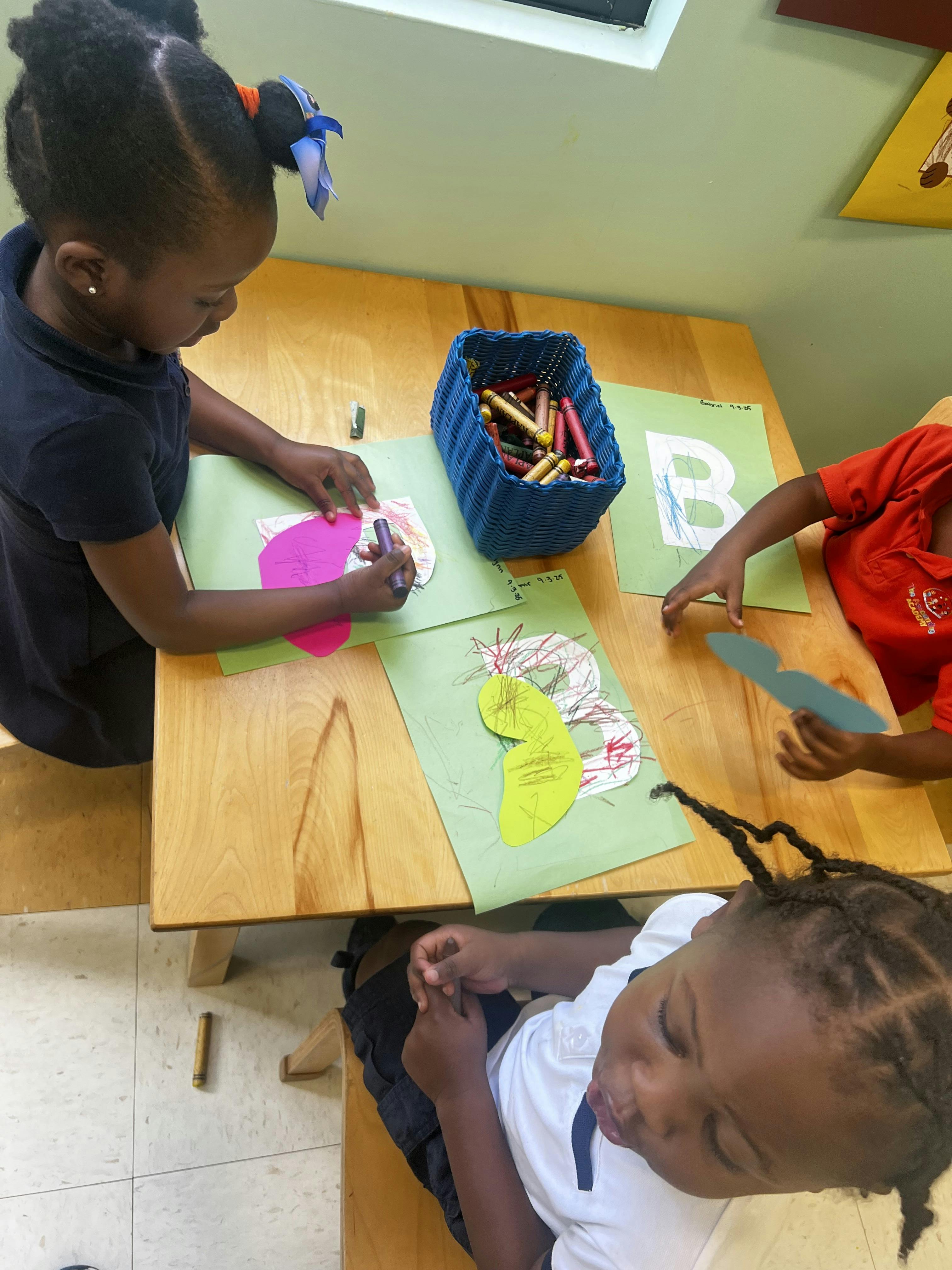 Children doing crafts at a table in a classroom
