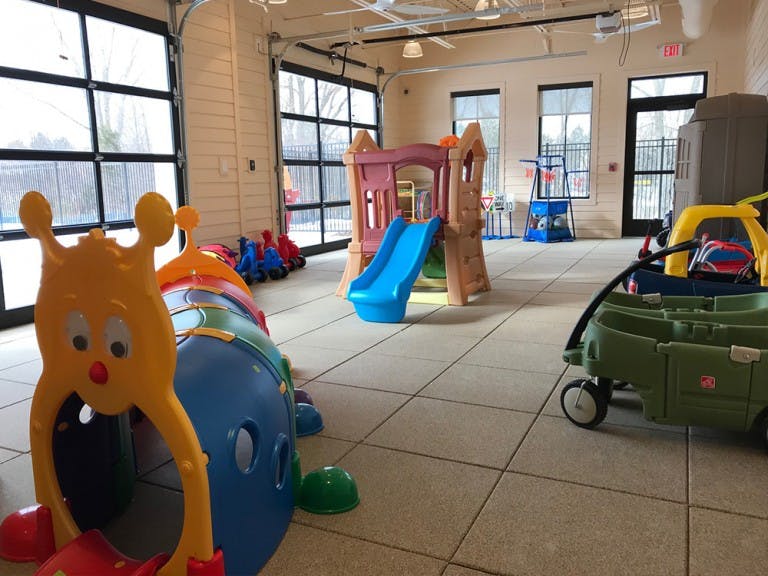 Indoor play area with a slide, crawl tunnel, and toy wagon