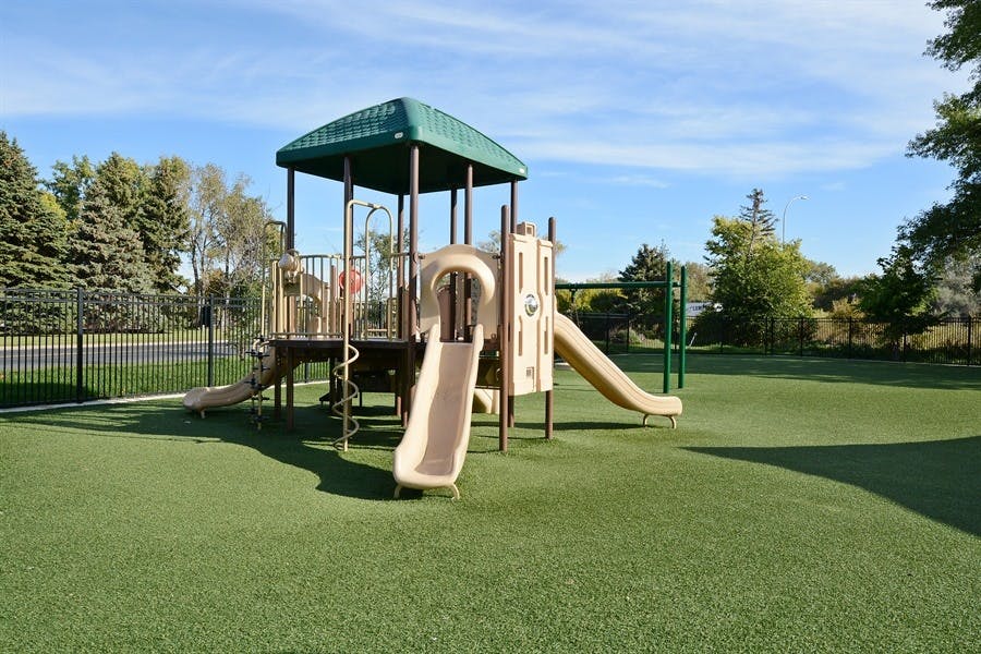 Playground with slides and climbing structure on green turf