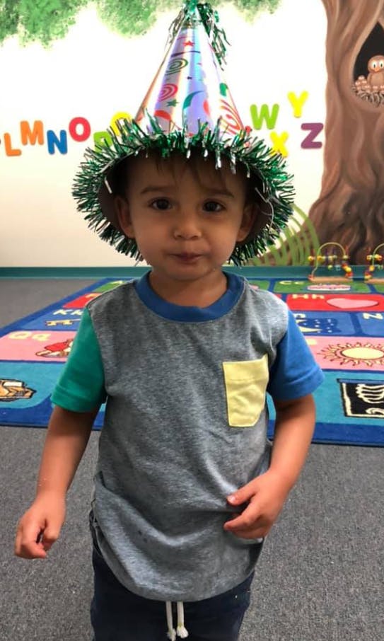Child wearing a party hat in a classroom