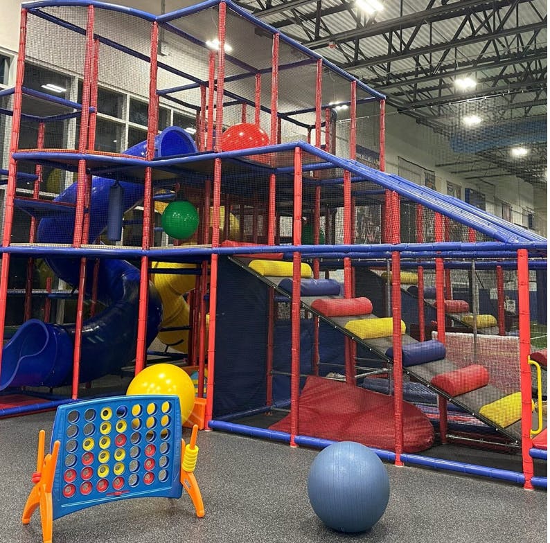 indoor playground with blue and red structures and colorful balls