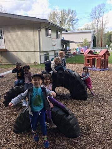 Children playing on large tires on a playground