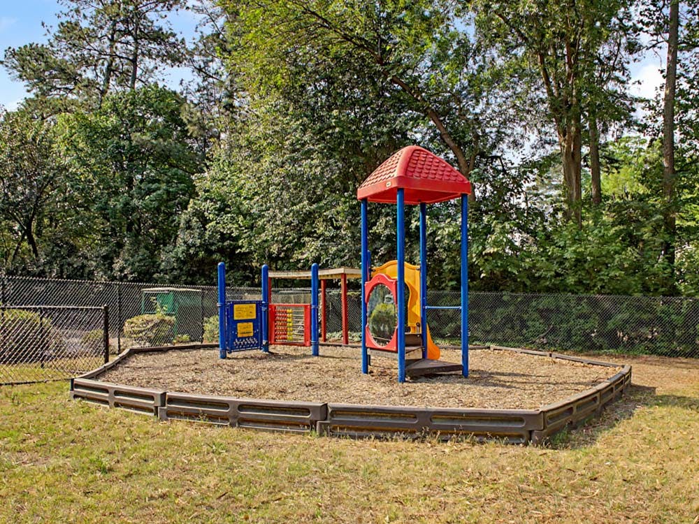 A colorful playground with a red roof, yellow slide, and blue support poles