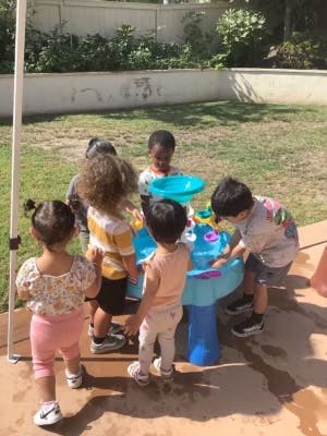 Children playing with a water table outdoors