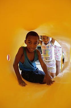 Two children in a yellow play tunnel