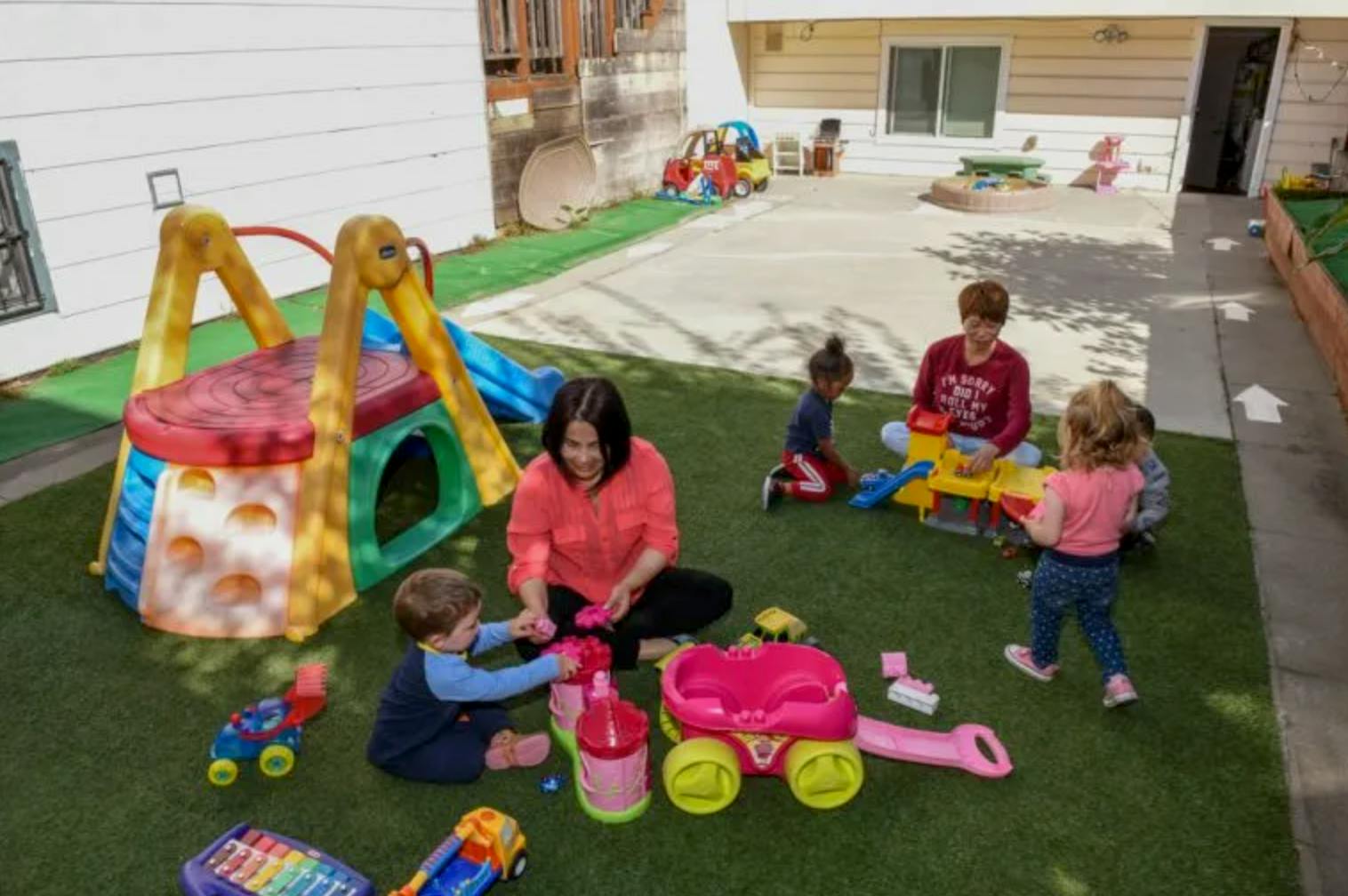 People and children playing with toys on a playground