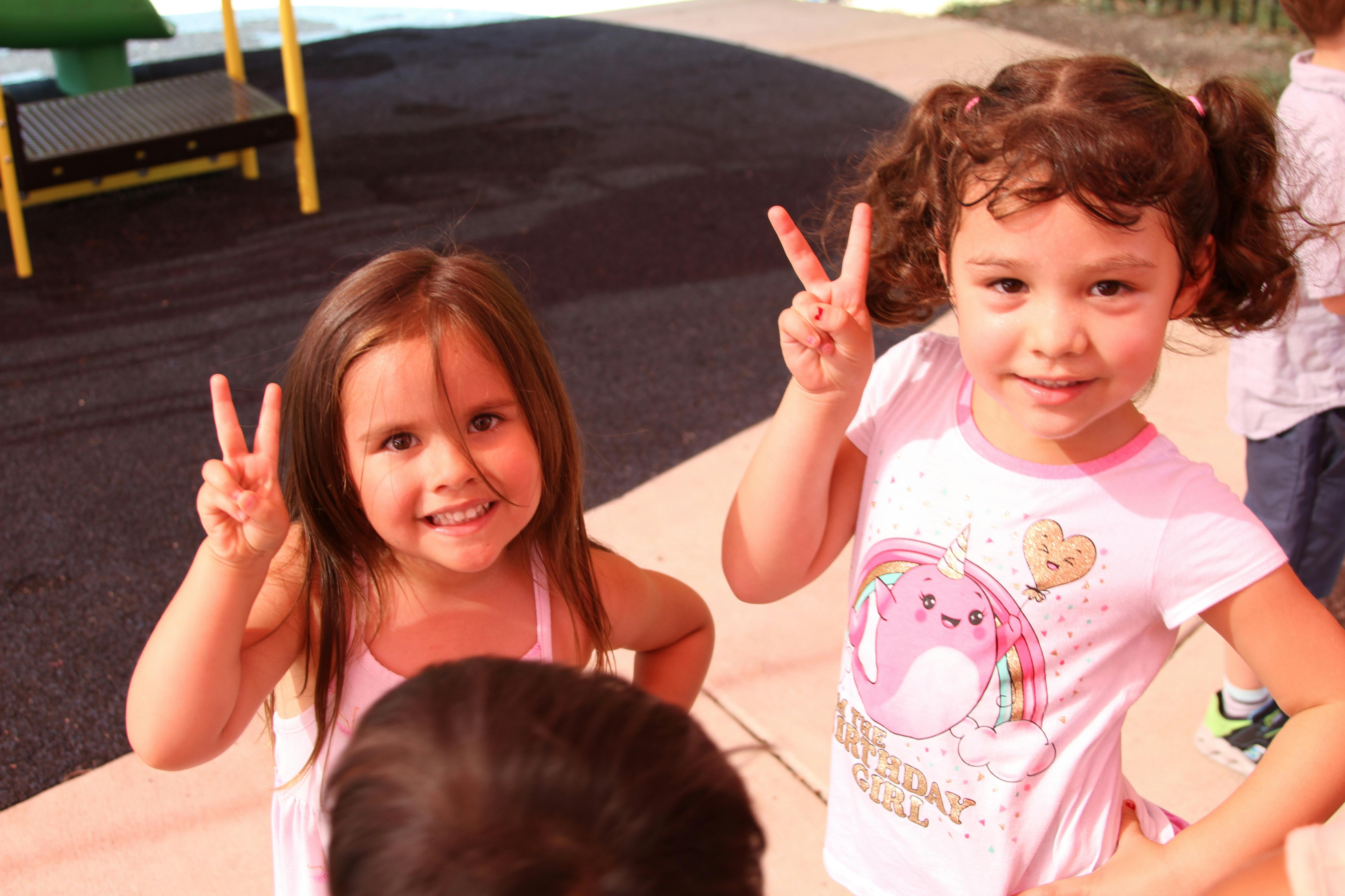 Two children making peace signs