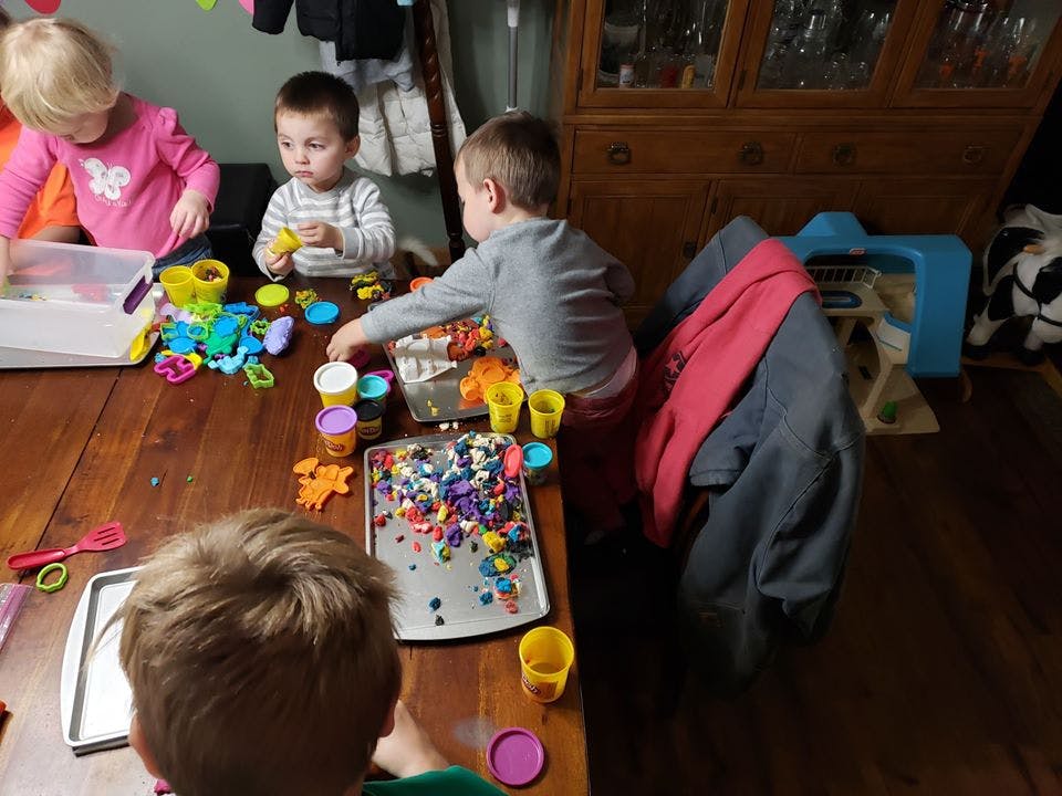 Children playing with colorful toys and craft supplies at a table