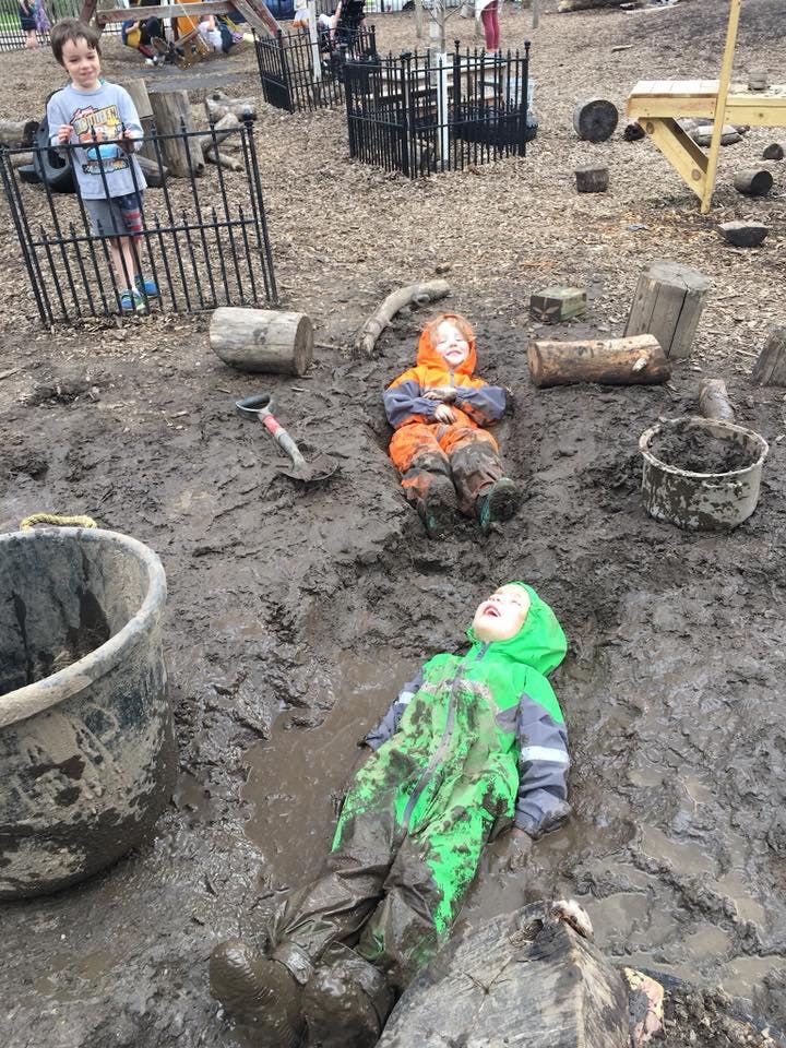 Children playing in a muddy outdoor area
