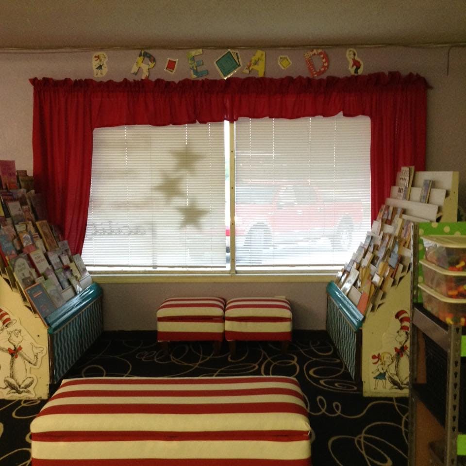 Reading nook with red and white striped ottomans and book displays