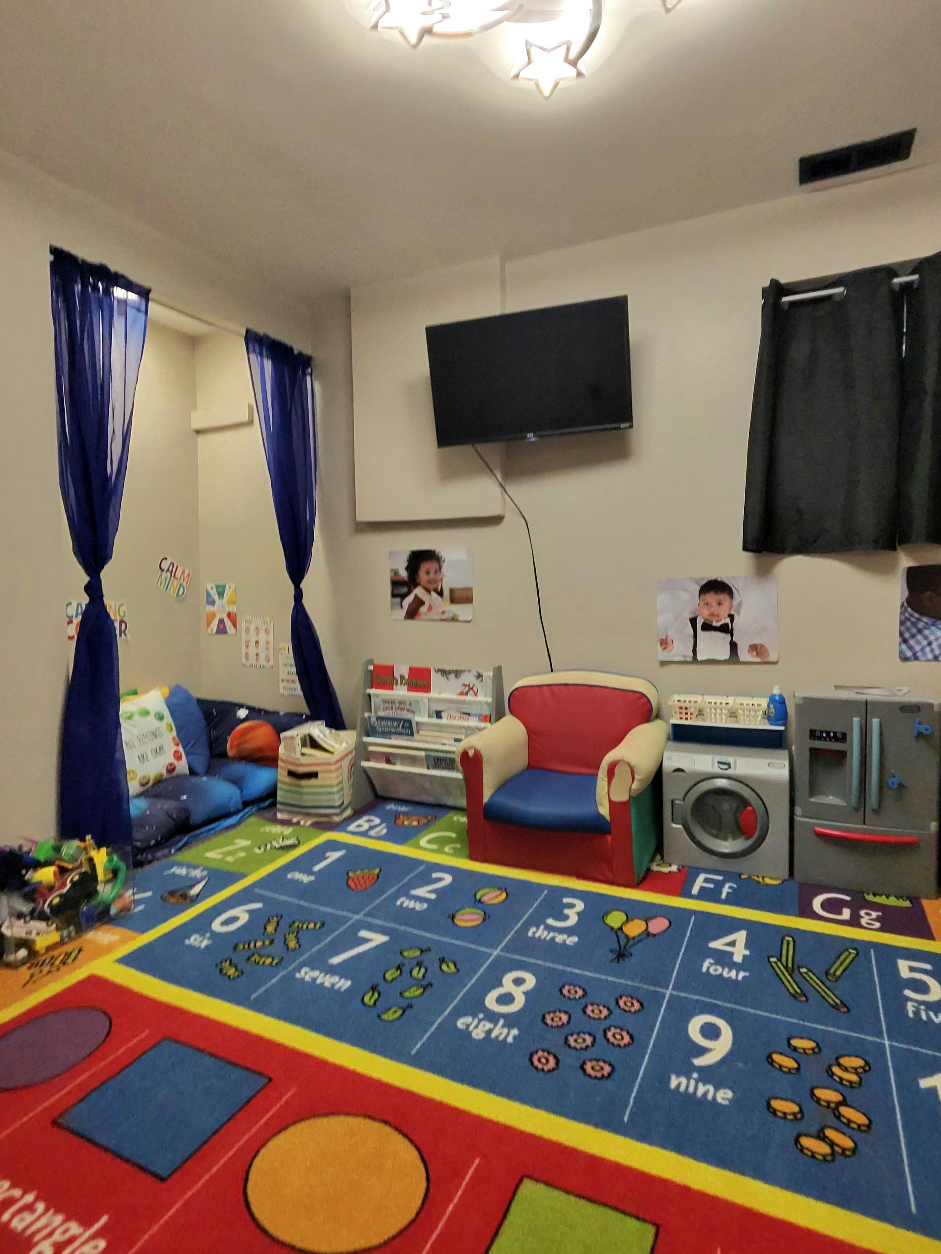 Colorful child play area with a numbered educational floor mat and small chairs