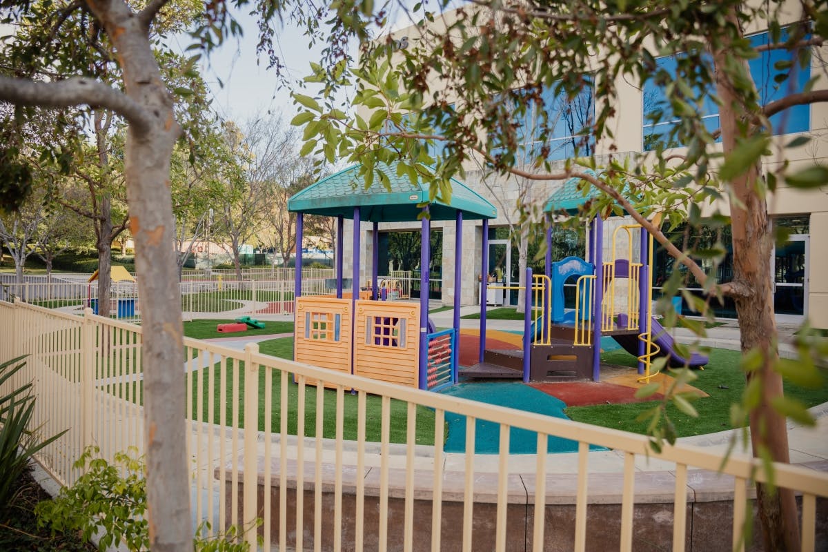 Outdoor playground with colorful equipment and a fence