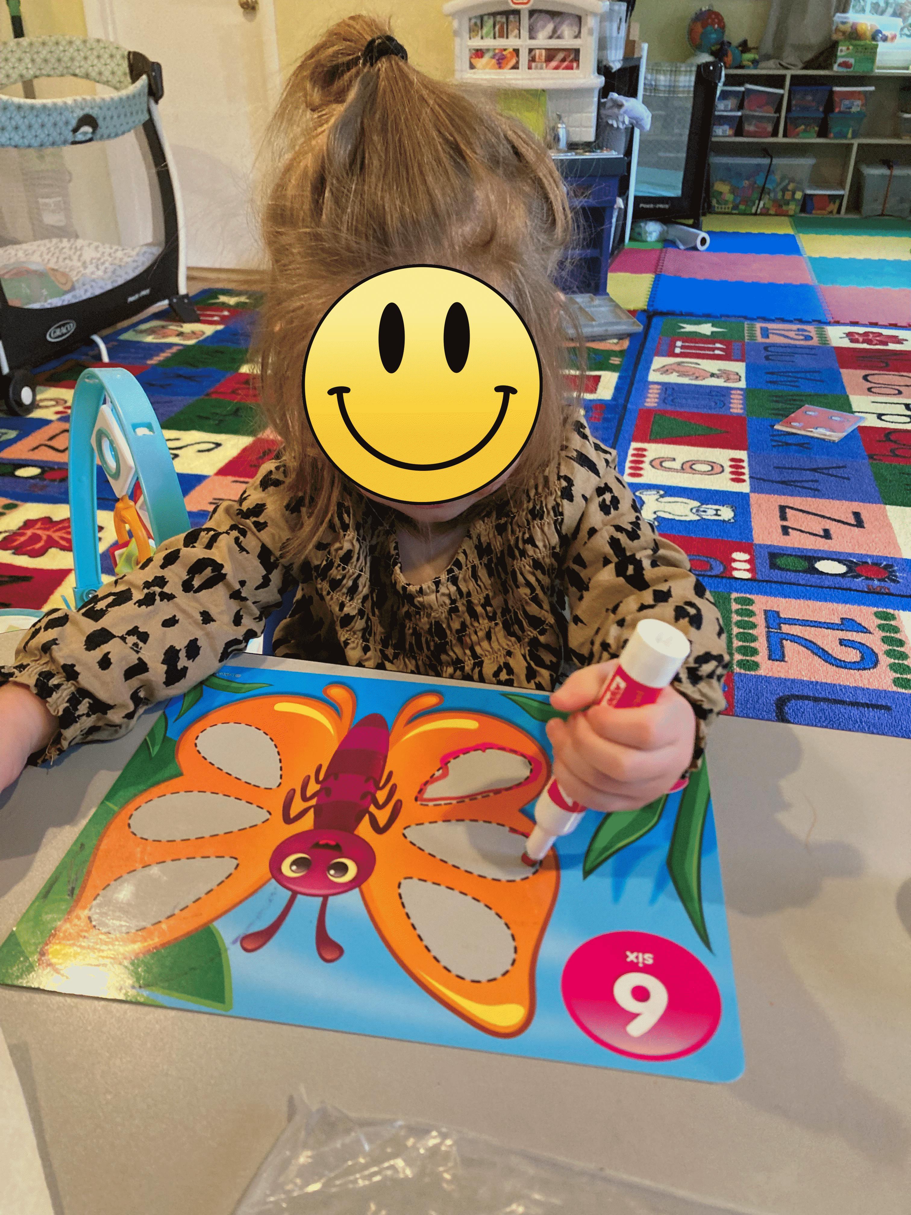 Child coloring a butterfly worksheet