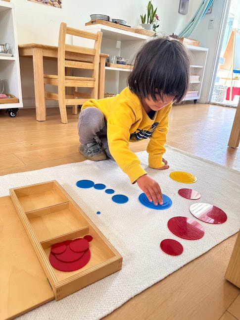 Child playing with colorful shapes on a mat