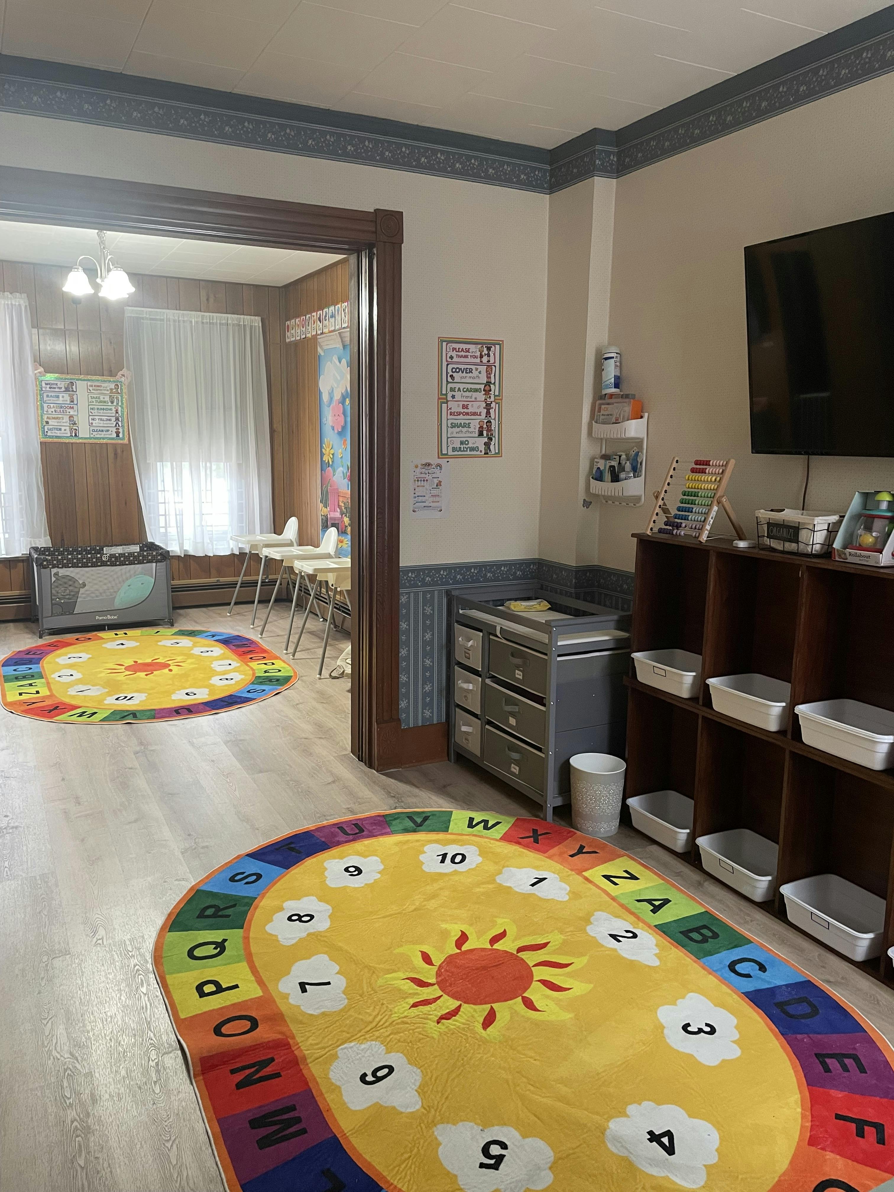 Classroom interior with colorful alphabet rugs and child furniture