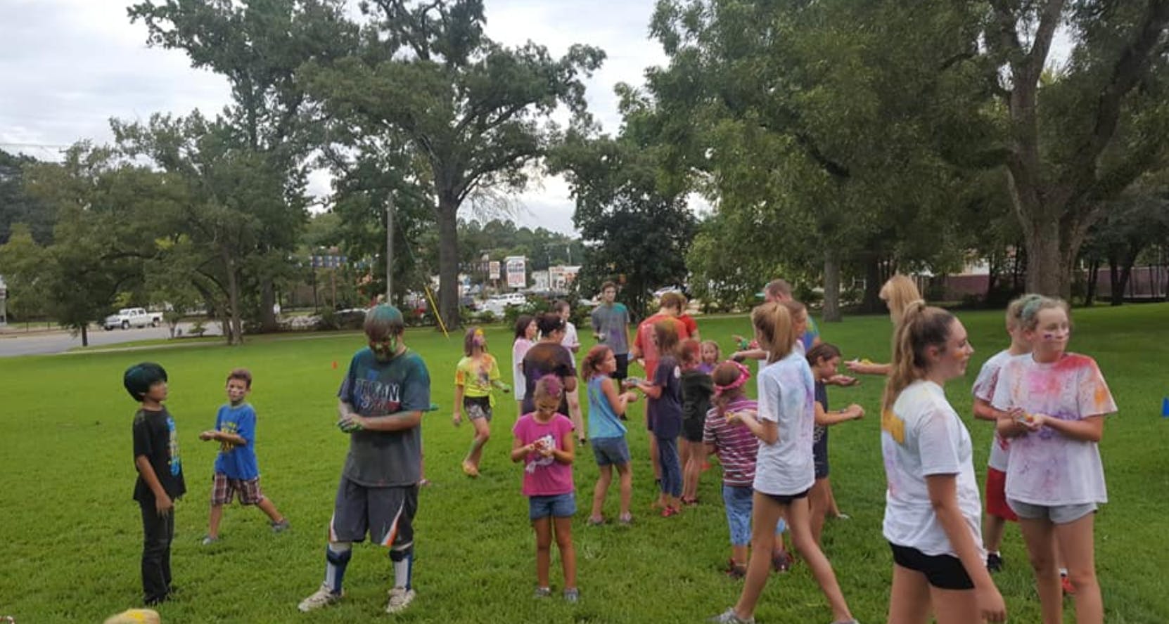 People and children gathered on a grassy field outdoors