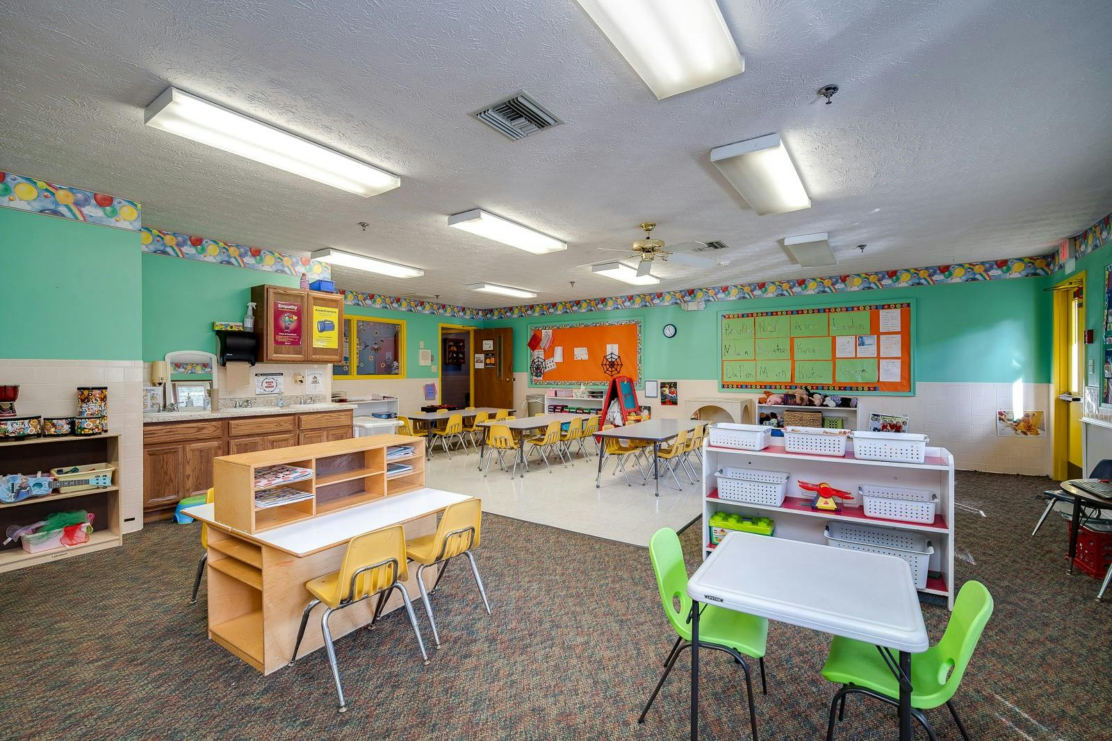 Empty classroom with small tables and chairs