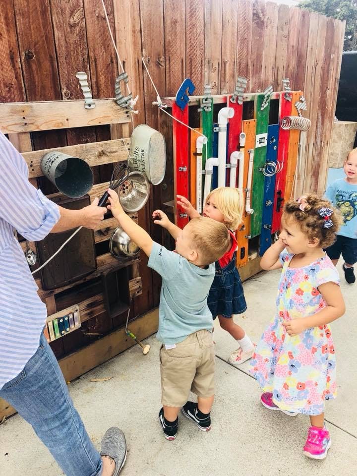 Person and children playing with a sound wall