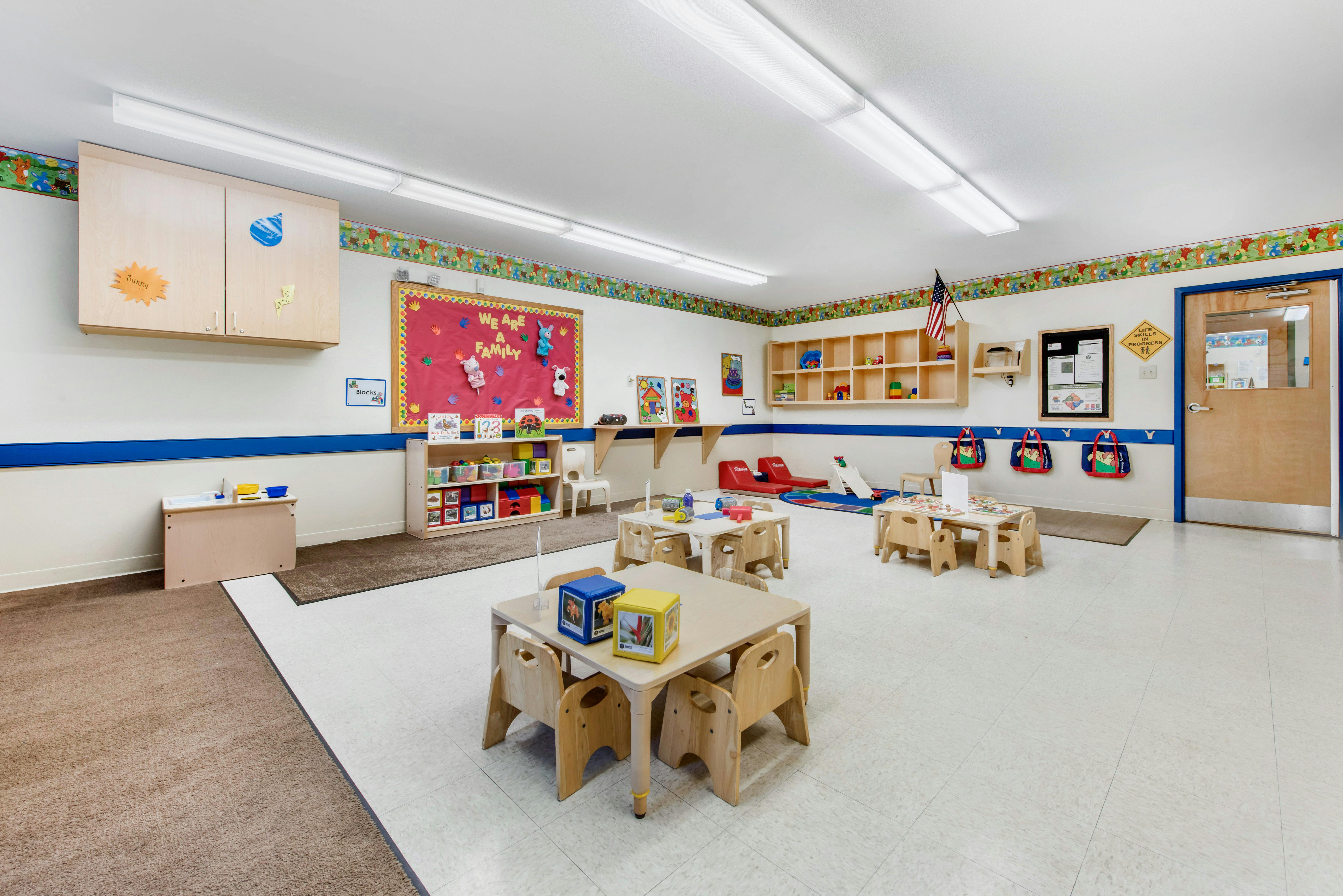 Empty colorful children's classroom with small tables and chairs