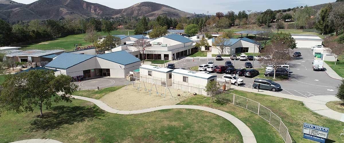 Aerial view of a school campus with buildings, portable classrooms, and parking