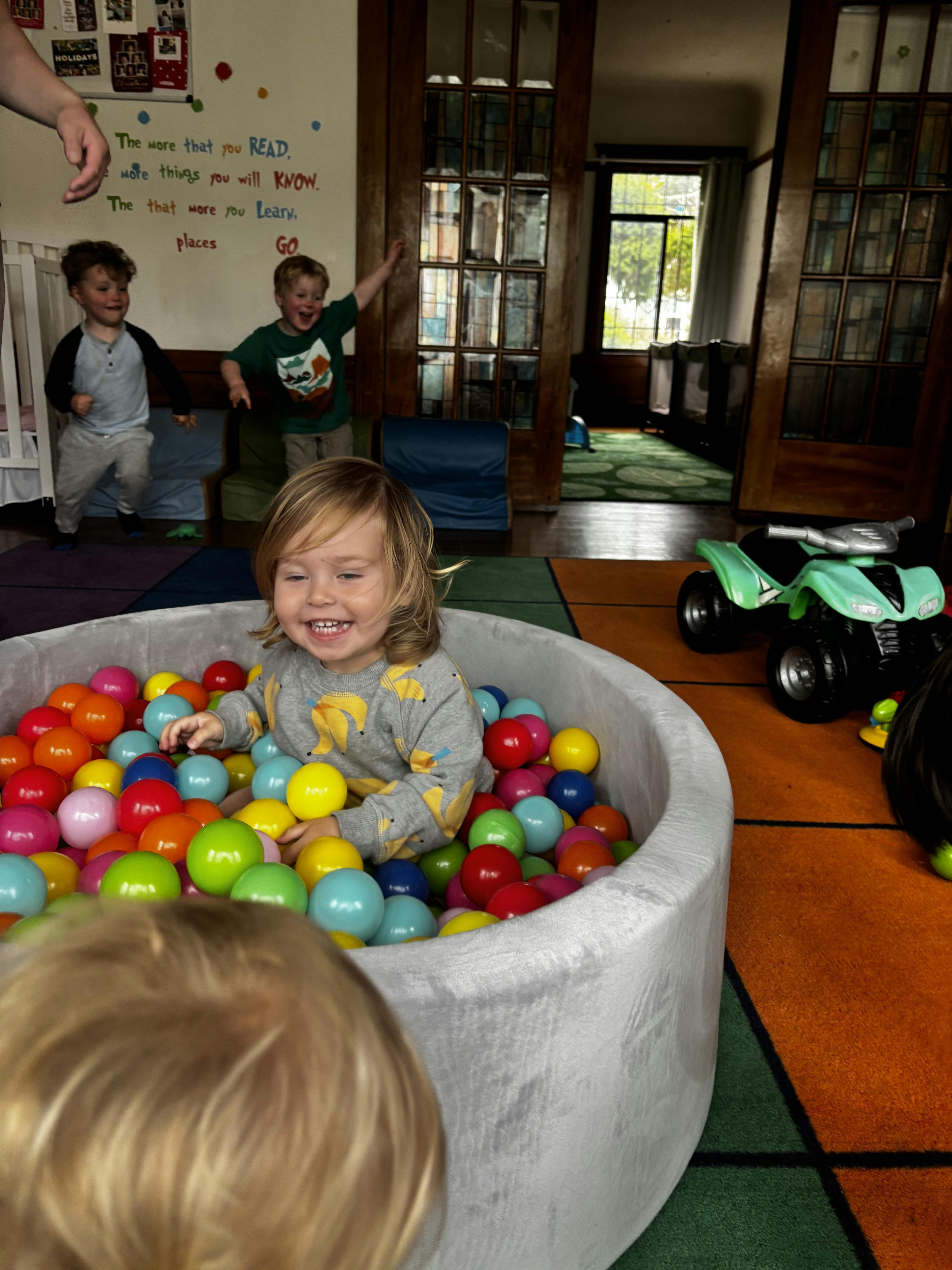 Children playing in a ball pit in a playroom